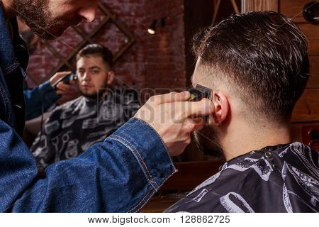 Haircut men Barbershop. Men's Hairdressers; barbers. Barber cuts the client machine for haircuts.