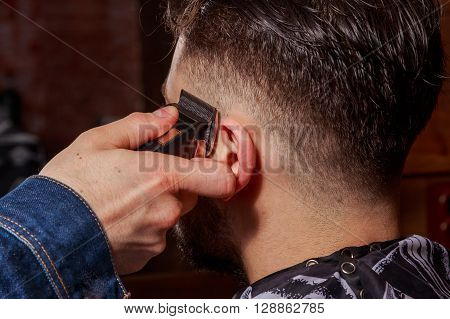 Haircut men Barbershop. Men's Hairdressers; barbers. Barber cuts the client machine for haircuts.