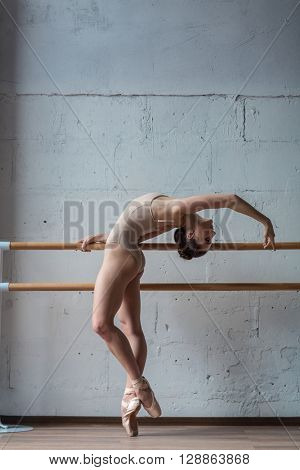 Young beautiful ballerina warming up in ballet class