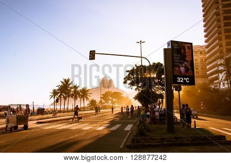 Rio de Janeiro, Brazil - March 27, 2016: People walk along a car-free Avenida Vieira Souto at sunset on Ipanema Beach.
