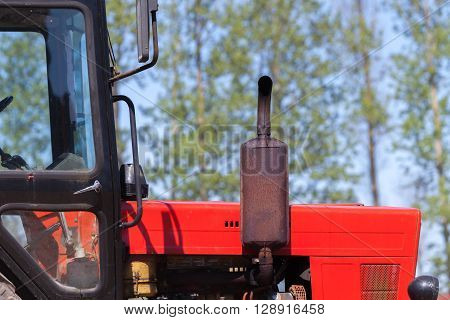red old tractor with trees in the background