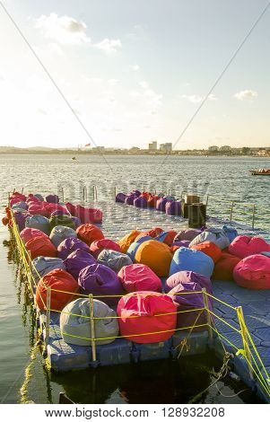 Colorful sitting cushions on the swimming platfom by the sea