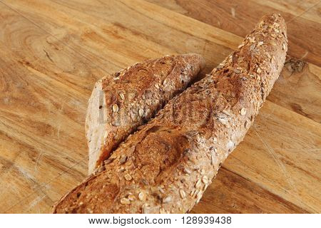 long french fresh rye baguette on light wooden table