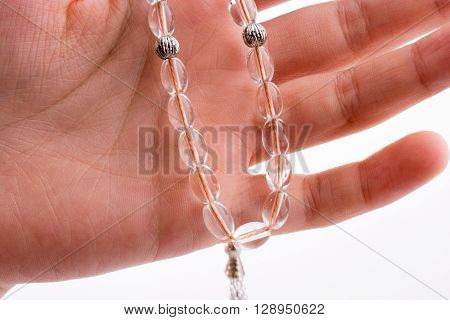 Hand holding a tespih on a white background