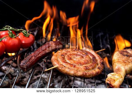 Grill concept.  roll sausage and tomatoes on grill with flare on backgroun