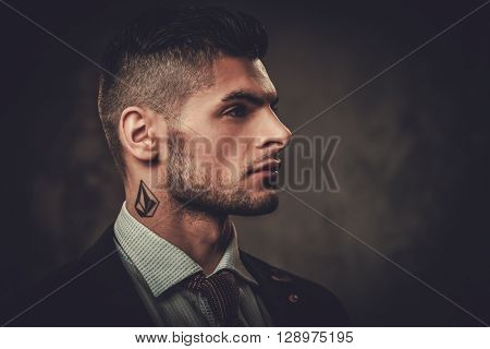 Serious well-dressed hispanic man posing on dark background. 