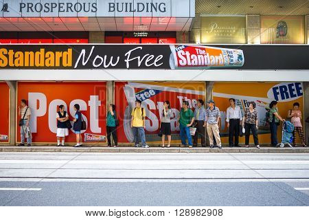 Hong Kong China - September 27 2007: People in a bus stop with advertising in the city center