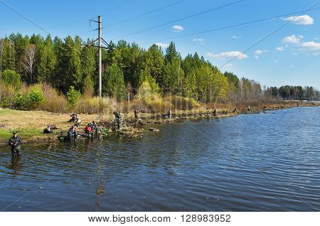MIDDLE URALS RUSSIA - MAY 5 2016: Many fishermen catch fish in the mouth of the river Kanava during the spring fishing activity. Middle Ural. Russia
