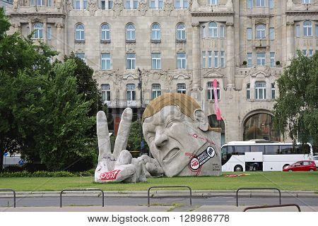 BUDAPEST HUNGARY - JULY 13: A Giant Sculpture in Budapest on JULY 13 2015. Massive Figure Poked His Head and Fingers a Sculpture Named Repost by Hungarian Artist Ervin Lorant Herveat at Szechenyi Istvan Square in Budapest Hungary.