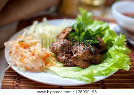 grilled shashlik with pickled cabbage and salad and fragrant herb