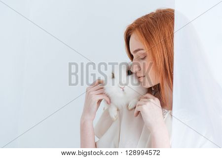 Redhead woman posing with rabbit isolated on a white background