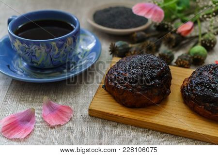 A Mug Of Black Tea And Buns With Poppy Seeds For Breakfast.