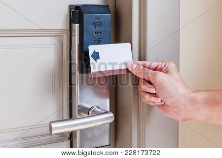 Hotel Door - Close Up Of Hand Young Man Holding A Keycard In Front Of The Electronic Sensor Of A Roo