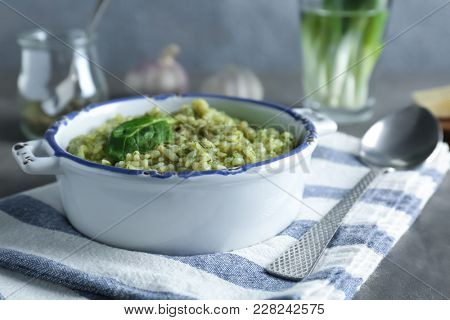 Dish with tasty spinach risotto on table, closeup