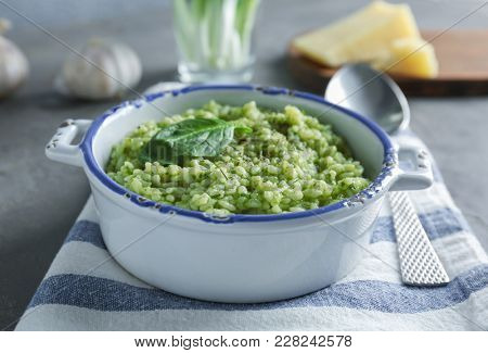 Dish with tasty spinach risotto on table, closeup