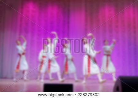 Folk Dances Of Children And Teens Theme Abstract Blur Background With Bokeh Effect. Teens In Bright 