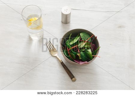 Vegetarian Biodynamic Food. Bowl Salad Spinach, Beet Leaves, Water, Lemon
