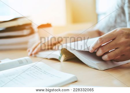 High School Or College Students Studying And Reading In Library