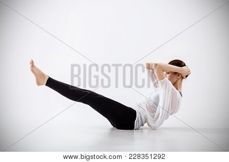Young Woman Doing Yoga Exercise. Stretching On The Floor.