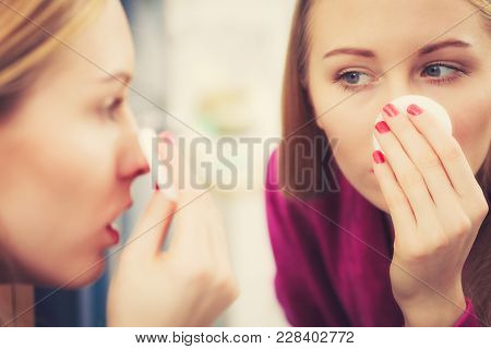 Woman Using Cotton Pad To Remove Make Up