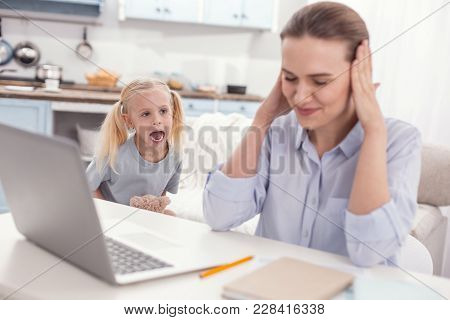 Child Hysterics. Mischievous Small Pretty Girl Yelling While Mother Sitting And Shutting Her Eyes