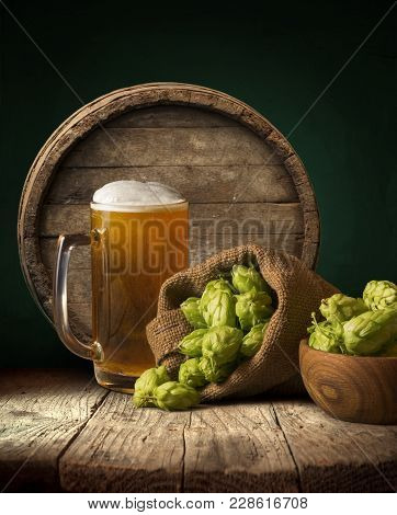 Oktoberfest Beer Barrel And Beer Glasses With Wheat And Hops On Wooden Table.
