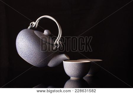 Old Style Kettle And Coffee Cups In Creative Still Life With Flying Kettle
