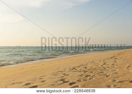 Pilai Beach And Old Wooden Bridge With Footprints Along The Shore