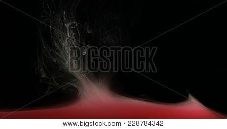 Red Drops, Waves And Clouds Of Ink Creating Dynamic Shapes In Water. Abstract Effects Of Paint Color