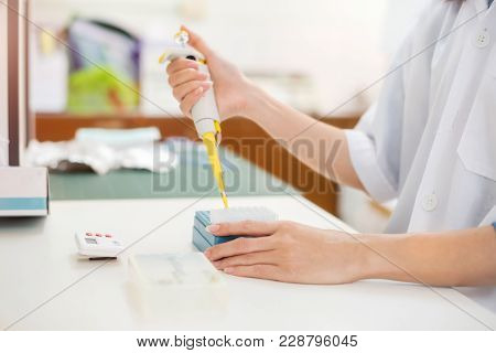 Young Woman Student As Asia Scientific Researcher Holding Autopipette Liquid Solution In A Laborator