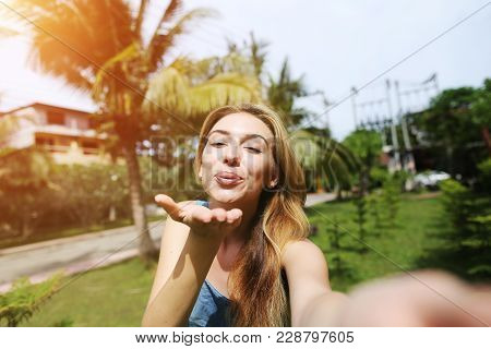 Happy Joyful Woman Send Air Kiss To Comera Taking Selfie, Traveling To Sunny Thailand With Palms And