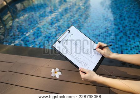 Woman Holds Pen And Visa Application In Uae Dubai, Contributes Her Data For New Trip To Foreign Coun