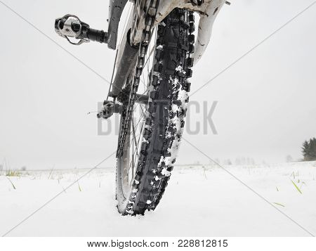 Close-up Of The Rear Wheel Of Mountain Bicycle In Snowy Meadow In The Countryside. Detail Of The Mou