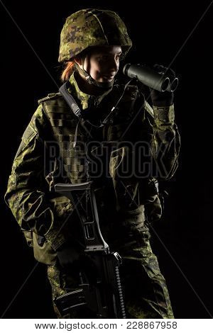 Portrait Of Armed Woman With Camouflage. Young Female Soldier Observe With Binoculars. Child Soldier