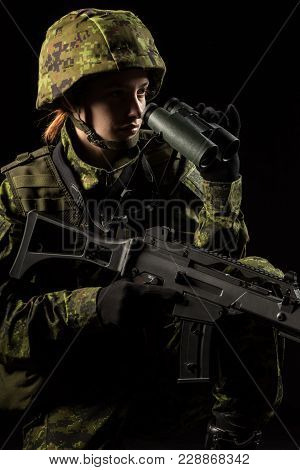 Portrait Of Armed Woman With Camouflage. Young Female Soldier Observe With Binoculars. Child Soldier