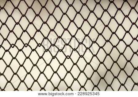 Background And Texture For Design. Abstract Chain Link Fence Texture Against Grungy Gray Color Wall.