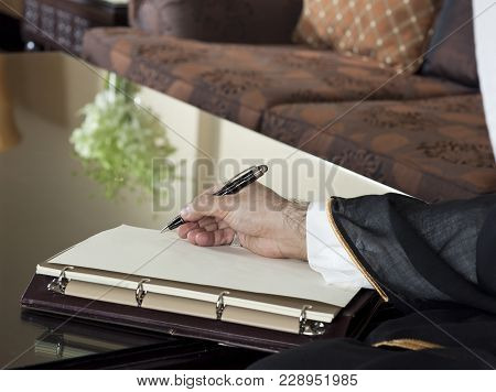 Saudi Arabian Man Hand Writing On A Notebook