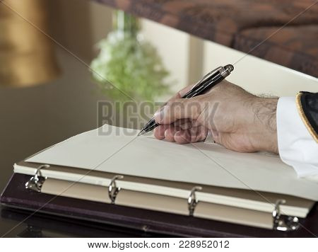 Saudi Arabian Man Hand Writing On A Notebook