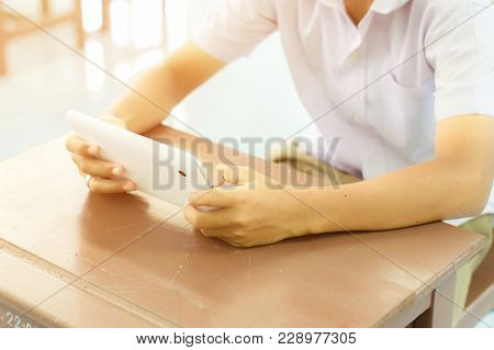 Hands Of Asian Schoolboy Holding The White Tablet To Searching Knowledge By Using Wifi Internet Conn