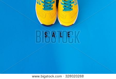 Pair Of Yellow Shoes On Blue Background Hold A White Card Text Sale.top View, Flay Lay, Sale Concept