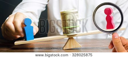 Wooden Figures Of Man And Women On The Scales. Concept Of Gender Pay Gap. Income Inequality. Oppress