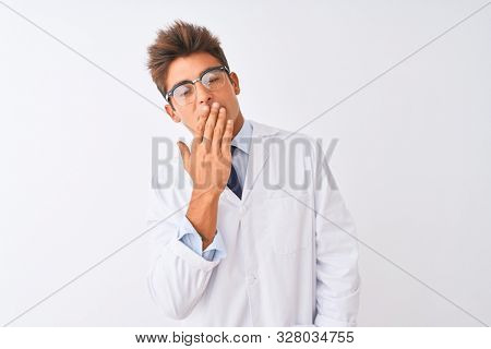 Young handsome sciencist man wearing glasses and coat over isolated white background bored yawning tired covering mouth with hand. Restless and sleepiness.
