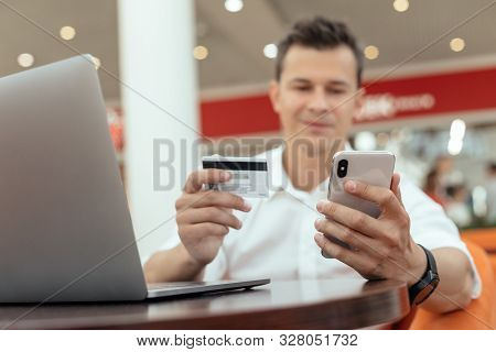 Man Using Smartphone And Laptop Computer For Online Shopping . Credit Card