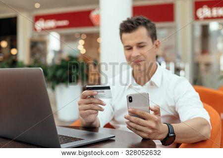 Man Using Smartphone And Laptop Computer For Online Shopping . Credit Card