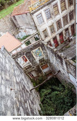 Porto, Portugal - 24.08.2019: Quarter With Destroyed Houses Under The Luis I Bridge In Porto. Buildi