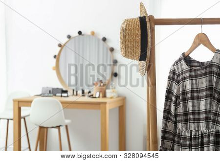 Hanger With Stylish Cloth And Hat On Rack In Makeup Room. Space For Text