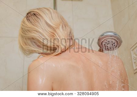Blonde Girl In The Shower With Water Drops On The Skin, Photo From The Back Close-up