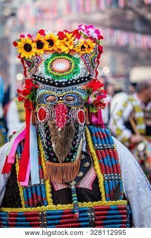 Mummers perform rituals to scare evil spirits at Surva festival at Pernik in Bulgaria. The people with the masks are called Kuker (kukeri). Very colorful and shiny mask.