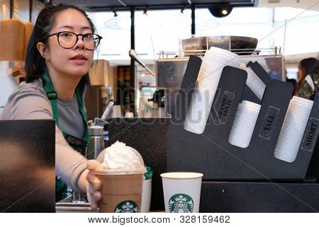 Burnaby, BC, Canada - March 26, 2019 : Motion of barista making coffee for customer at Starbucks store