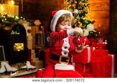 Gifts For Winter Holidays At Fire Place. Little Boy With Christmas Presents. Joy And Happiness. Chil